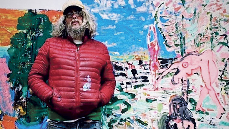 Luke Hannam standing in front of wall painting